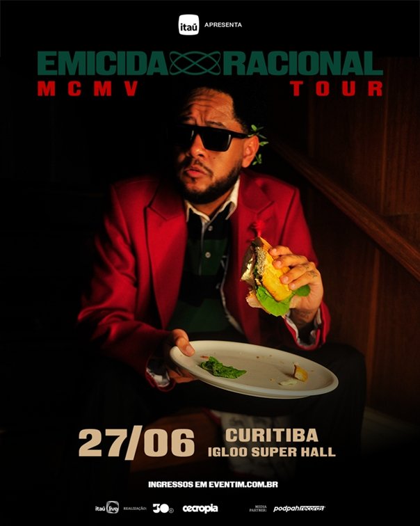 Foto do rapper Emicida com iluminação contrastante de tons avermelhados e sombras
