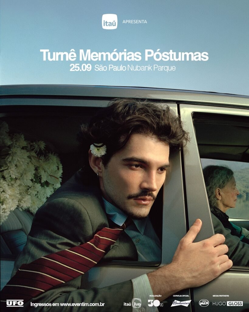 Cartaz promocional da "Turnê Memórias Póstumas". A imagem mostra um homem de cabelos escuros, bigode e terno cinza com gravata listrada vermelha, olhando para fora da janela de um carro prateado com uma flor branca atrás da orelha. No banco traseiro, há um buquê de flores brancas e o perfil de uma mulher idosa olhando pela janela. No topo, sob um céu claro, destaca-se o texto anunciando o show no dia 25 de setembro no Nubank Parque, em São Paulo, apresentado pelo Itaú, com vendas na Eventim.