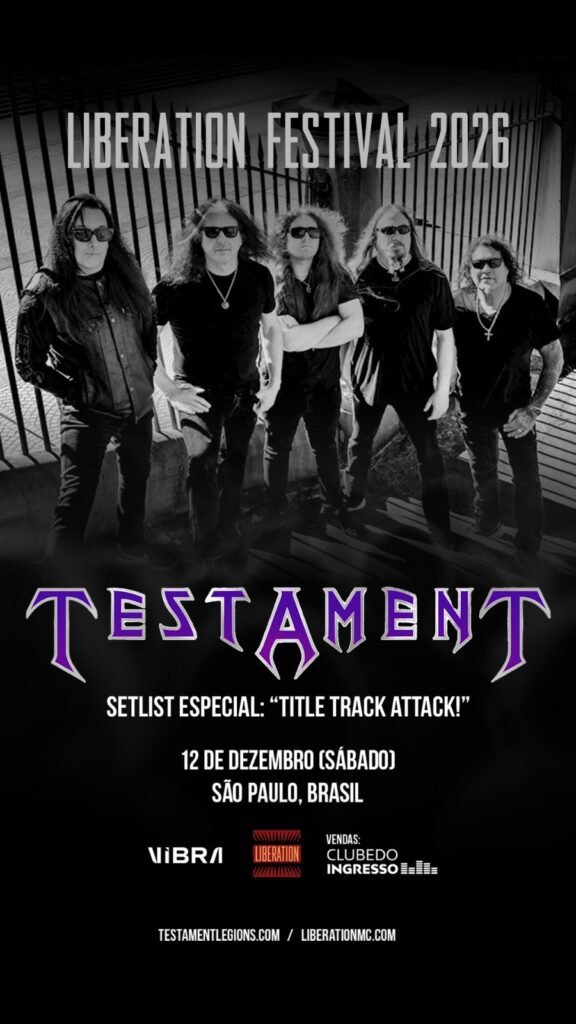 artaz promocional da banda de thrash metal Testament no Liberation Festival 2026. A metade superior traz uma fotografia em preto e branco dos cinco integrantes da banda posando ao ar livre, todos de roupas escuras e óculos de sol, em frente a uma grade de ferro. Na metade inferior, sobre fundo preto, destaca-se o logotipo da banda "TESTAMENT" em roxo com contorno branco. Logo abaixo, constam as informações do evento: o aviso "SETLIST ESPECIAL: 'TITLE TRACK ATTACK!'", a data de 12 de dezembro (sábado) em São Paulo, Brasil, e a indicação do local Vibra São Paulo. No rodapé, estão as marcas da Liberation, Clube do Ingresso e os sites oficiais da banda e do festival.